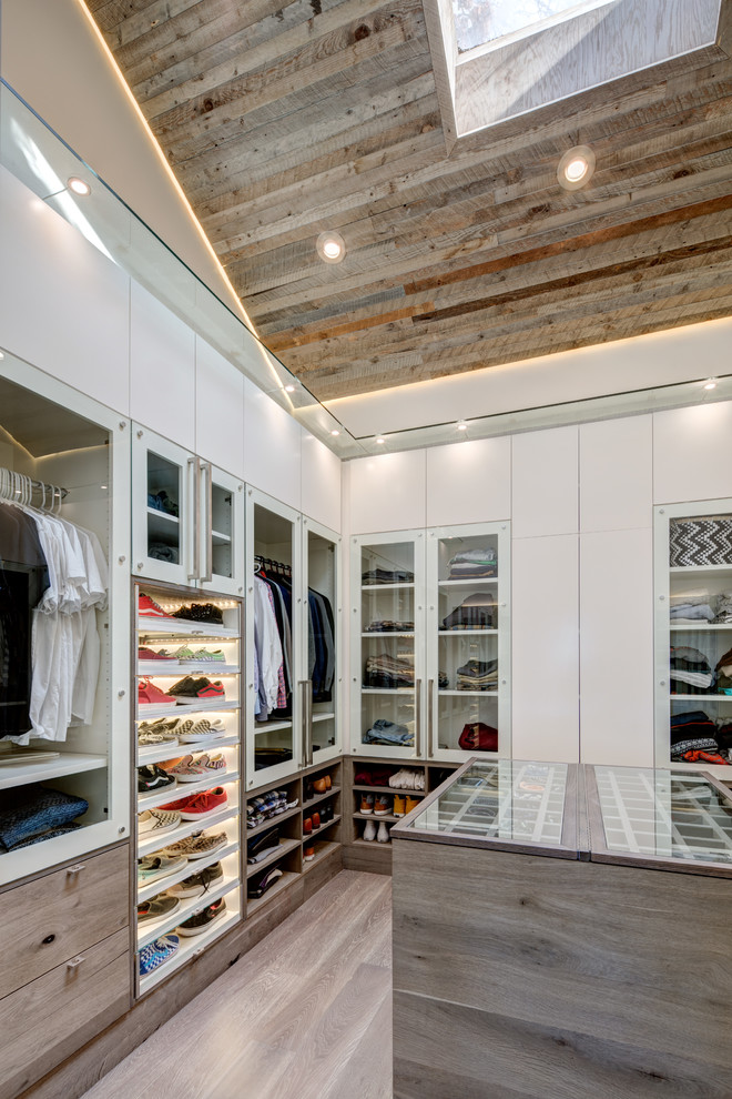 Inspiration for a contemporary men's walk-in wardrobe in Salt Lake City with flat-panel cabinets, white cabinets, dark hardwood floors and beige floor.