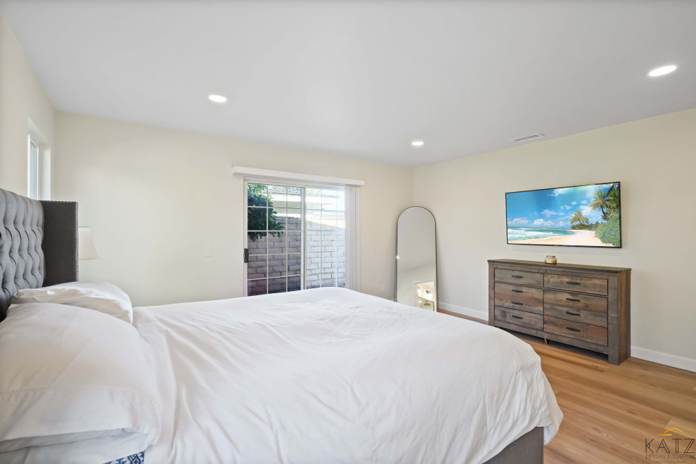 Imagen de habitación de invitados grande con paredes beige, suelo de madera en tonos medios y suelo naranja