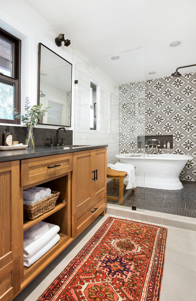 This is an example of a mid-sized country master bathroom in Seattle with a freestanding tub, a shower/bathtub combo, a one-piece toilet, an undermount sink, granite benchtops, a double vanity and a built-in vanity.