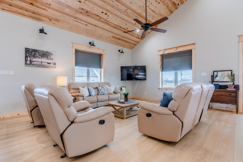 This is an example of a mid-sized country open concept living room in San Diego with grey walls, vinyl floors, a wall-mounted tv, beige floor and wood.