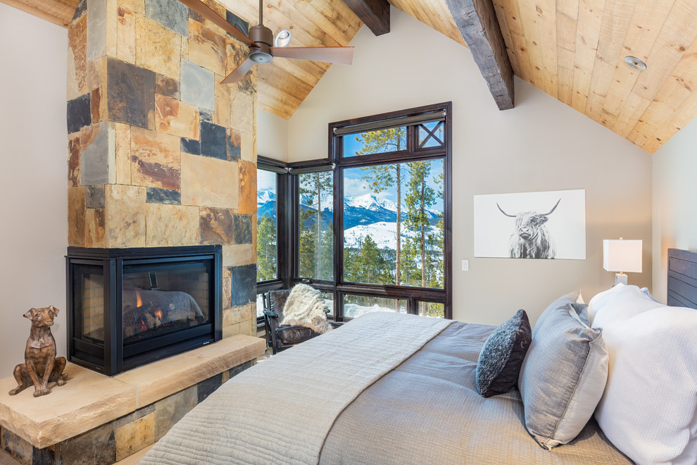 Design ideas for a country master bedroom in Denver with white walls, a wood stove and a stone fireplace surround.