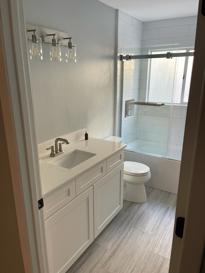 Foto di una stanza da bagno per bambini moderna di medie dimensioni con ante bianche, top in quarzo composito, top bianco, mobile bagno incassato e un lavabo