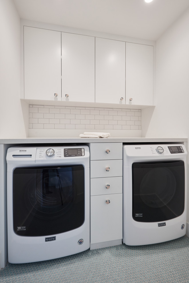 Design ideas for a mid-sized country single-wall dedicated laundry room in Los Angeles with an undermount sink, flat-panel cabinets, white cabinets, quartz benchtops, white walls, ceramic floors, a side-by-side washer and dryer, blue floor and white benchtop.