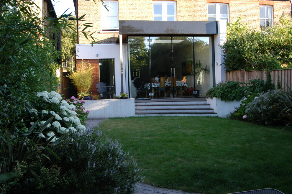 This is an example of a mid-sized contemporary backyard garden in London with decking.