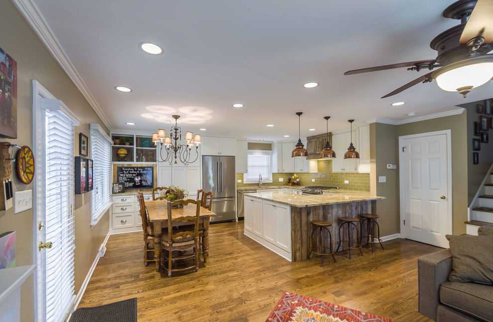 Mid-sized eclectic u-shaped open plan kitchen in Chicago with an undermount sink, shaker cabinets, white cabinets, granite benchtops, green splashback, glass tile splashback, stainless steel appliances, medium hardwood floors, a peninsula, brown floor, brown benchtop and wallpaper.