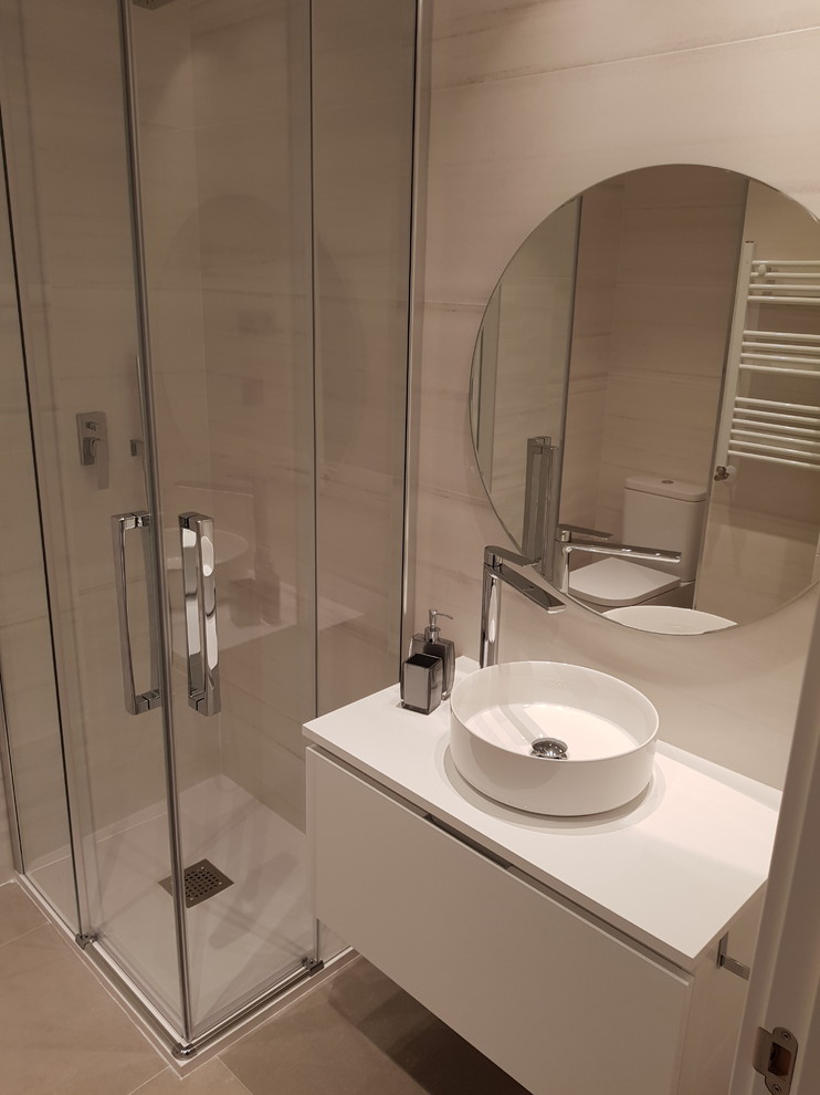 Modelo de cuarto de baño contemporáneo pequeño con puertas de armario blancas, ducha esquinera, aseo y ducha, lavabo sobreencimera, ducha con puerta con bisagras y encimeras blancas