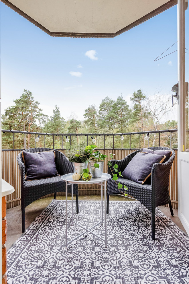 Design ideas for a scandinavian balcony in Stockholm with a roof extension and mixed railing.