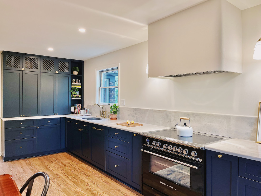 Inspiration for a large transitional l-shaped medium tone wood floor and brown floor eat-in kitchen remodel with an undermount sink, shaker cabinets, blue cabinets, quartzite countertops, stone slab backsplash, paneled appliances, no island and gray countertops