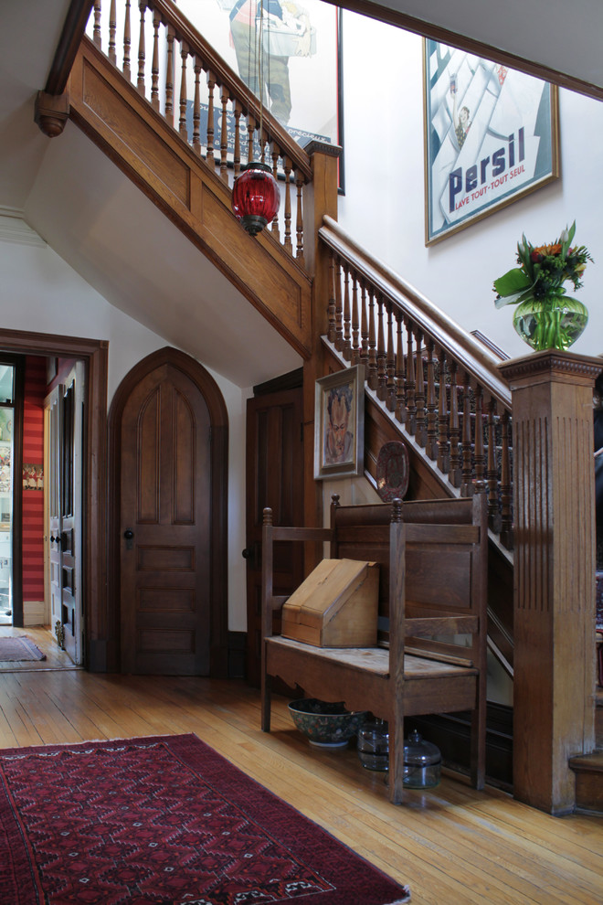 Traditional foyer in Montreal with white walls and light hardwood floors.