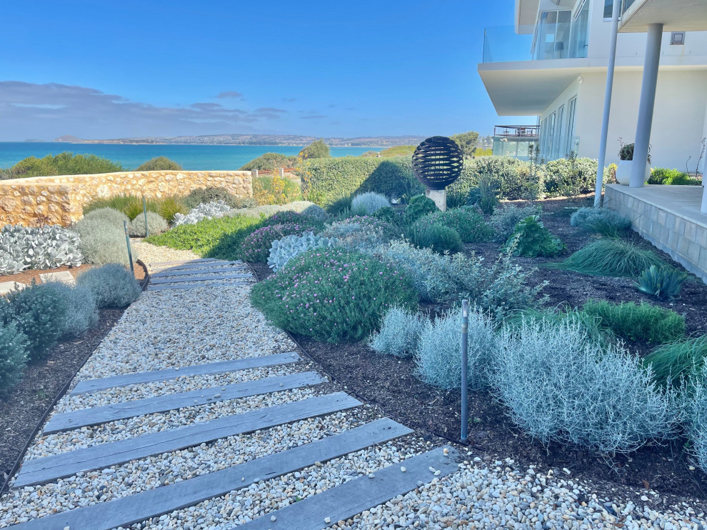 Design ideas for a coastal drought-tolerant stone fence landscaping in Adelaide.