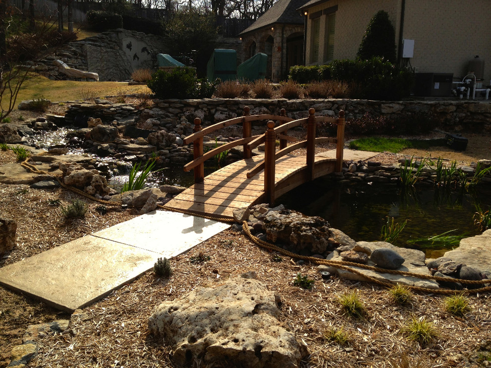This is an example of a mid-sized rustic partial sun backyard stone formal garden.