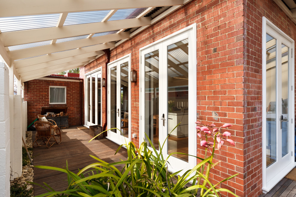Design ideas for a small traditional side yard screened-in verandah in Hobart with decking and a pergola.