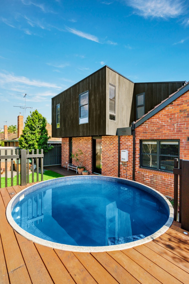 This is an example of a modern backyard round aboveground pool in Melbourne.