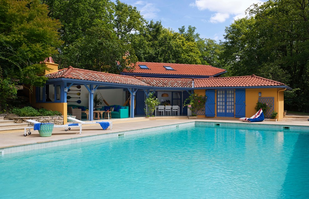 This is an example of a large mediterranean backyard rectangular pool in Madrid with a pool house.