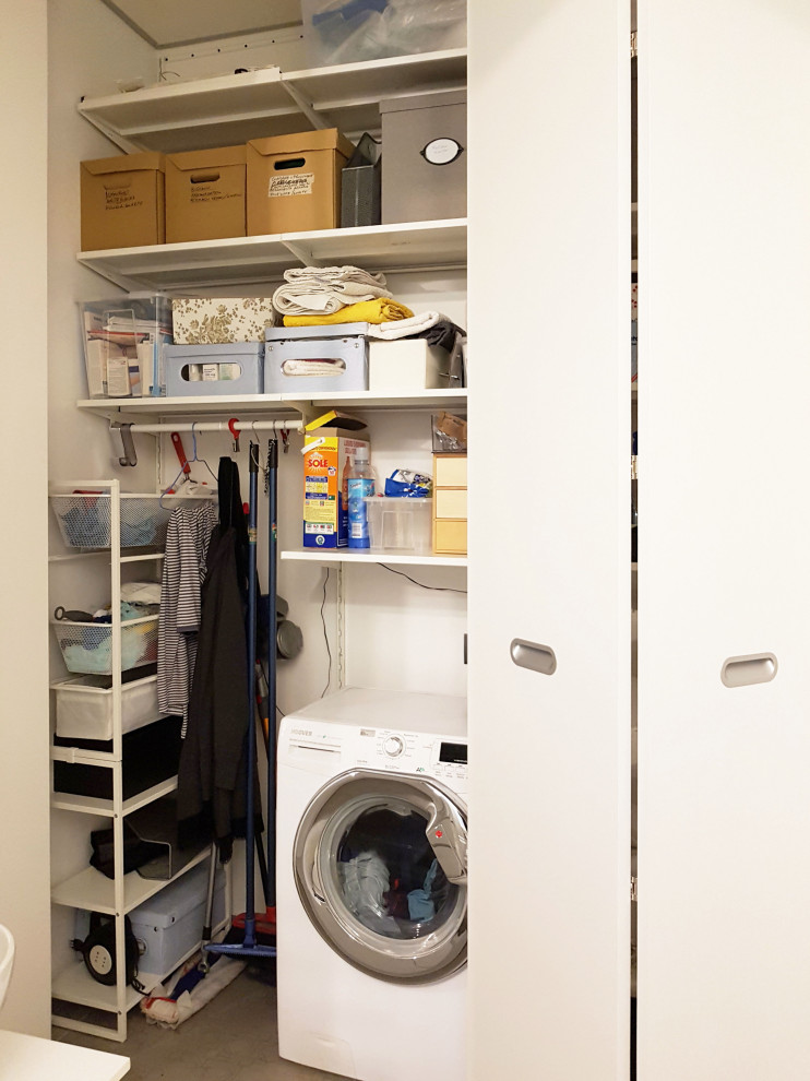 Immagine di una piccola lavanderia multiuso con ante lisce, ante bianche, pavimento in gres porcellanato, lavatrice e asciugatrice a colonna, pavimento grigio e pannellatura
