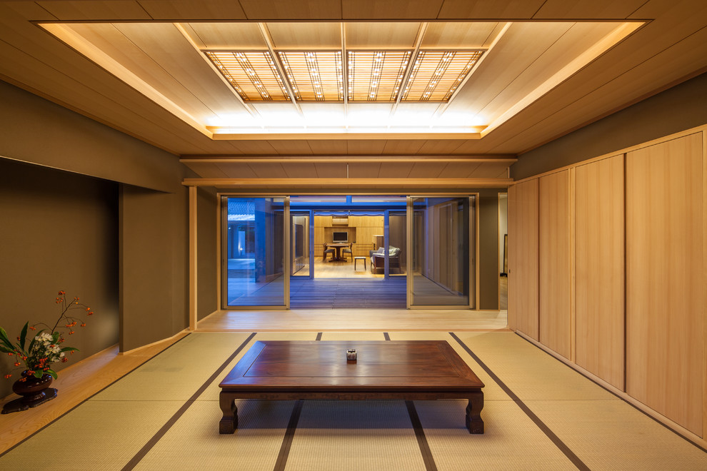 Asian dining room in Other with tatami floors, brown walls and green floor.