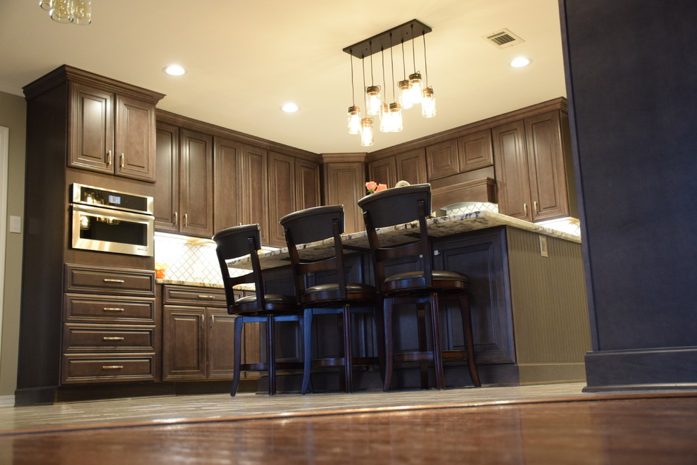 Inspiration for a mid-sized mediterranean l-shaped ceramic tile open concept kitchen remodel in Little Rock with a farmhouse sink, raised-panel cabinets, dark wood cabinets, granite countertops, stainless steel appliances and an island