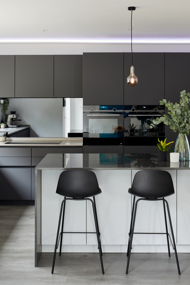 Inspiration for a mid-sized contemporary l-shaped eat-in kitchen in London with an undermount sink, flat-panel cabinets, grey cabinets, glass sheet splashback, stainless steel appliances and with island.