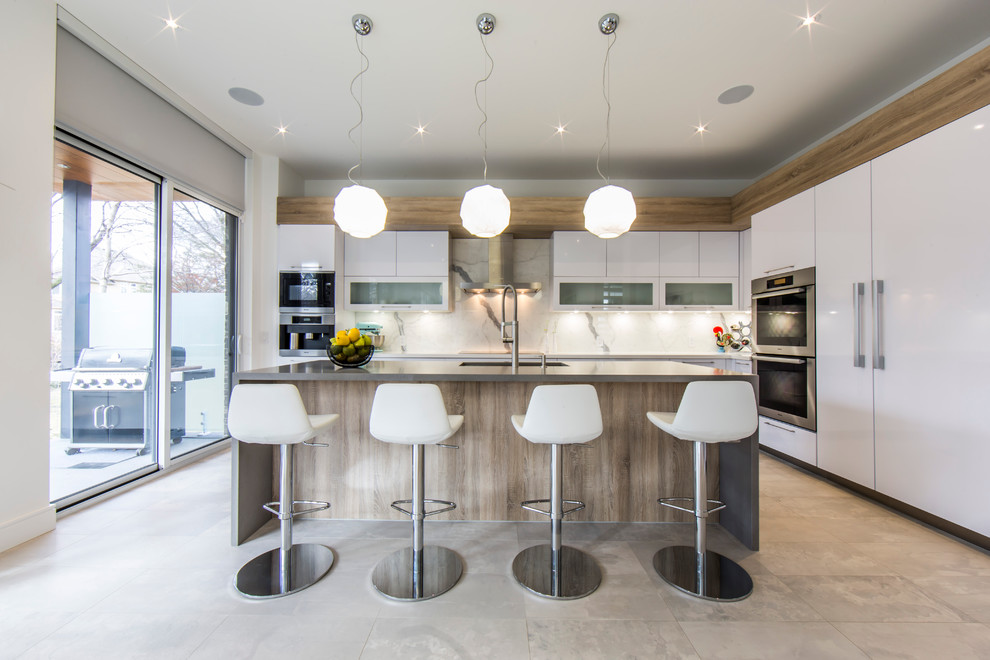Design ideas for a large contemporary l-shaped open plan kitchen in Toronto with an undermount sink, flat-panel cabinets, white cabinets, solid surface benchtops, white splashback, porcelain splashback, stainless steel appliances, porcelain floors and with island.