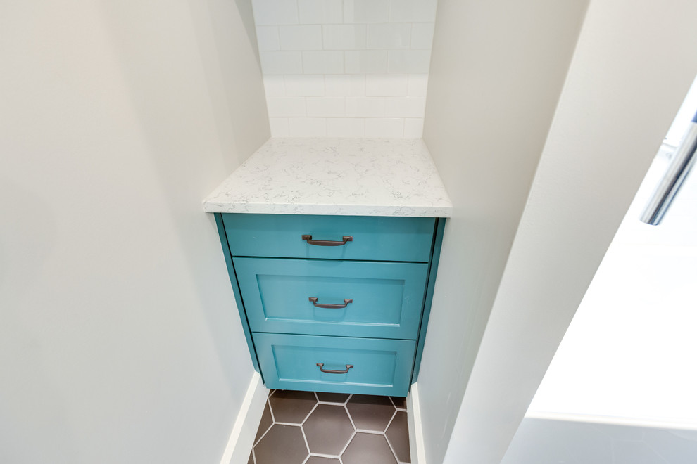 Inspiration for a small transitional kids bathroom in Birmingham with recessed-panel cabinets, turquoise cabinets, an alcove tub, a shower/bathtub combo, a two-piece toilet, white tile, subway tile, grey walls, porcelain floors, a console sink, engineered quartz benchtops, black floor, a sliding shower screen and white benchtops.
