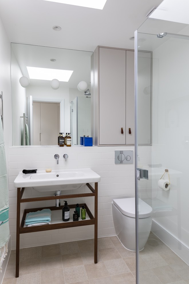 Inspiration for a small contemporary 3/4 bathroom in London with flat-panel cabinets, beige cabinets, a corner shower, a wall-mount toilet, white tile, ceramic tile, white walls, ceramic floors, a console sink, tile benchtops, beige floor, a hinged shower door and white benchtops.