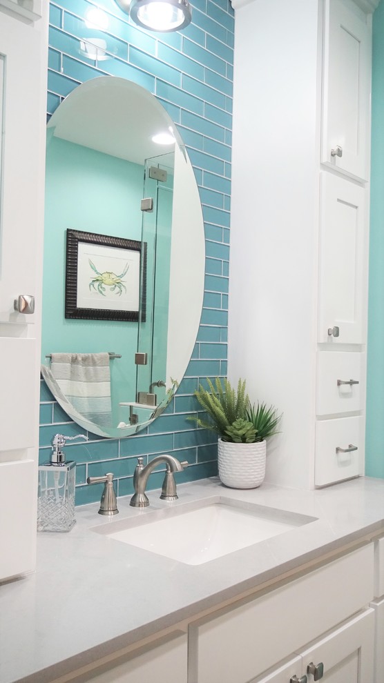 Photo of a mid-sized beach style master bathroom with shaker cabinets, white cabinets, an alcove shower, blue tile, glass tile, blue walls, porcelain floors, an undermount sink, quartzite benchtops, multi-coloured floor, a hinged shower door and grey benchtops.