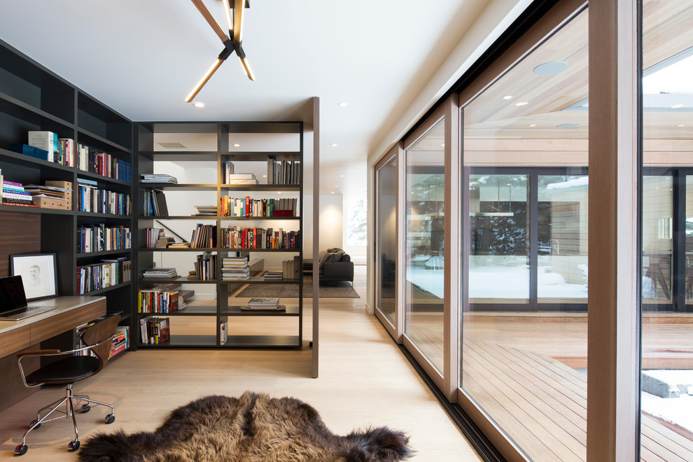 Scandinavian study room in Salt Lake City with white walls, light hardwood floors and a built-in desk.