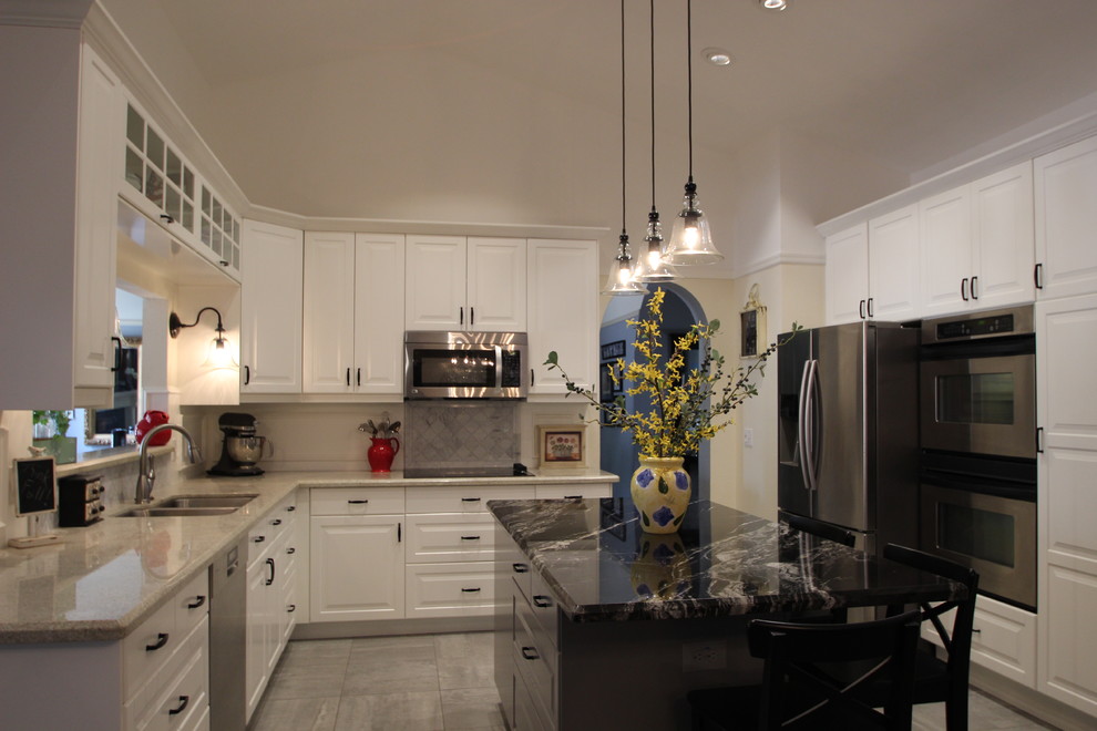 Mid-sized transitional u-shaped ceramic tile enclosed kitchen photo in Phoenix with a double-bowl sink, raised-panel cabinets, white cabinets, marble countertops, gray backsplash, ceramic backsplash, stainless steel appliances and an island