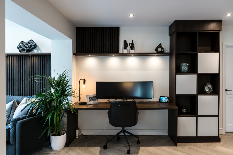 Imagen de despacho actual de tamaño medio con paredes blancas, suelo vinílico, estufa de leña, escritorio empotrado, suelo beige y panelado