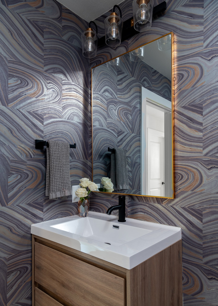 Example of a small mid-century modern wallpaper powder room design in Dallas with light wood cabinets, purple walls, white countertops and a floating vanity