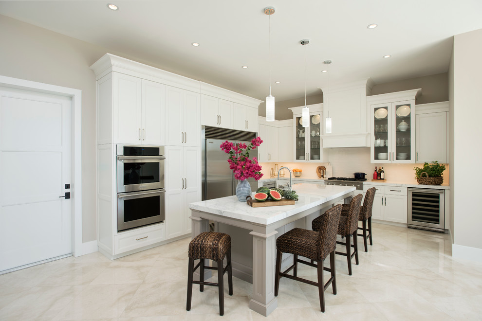 Open concept kitchen - mid-sized transitional l-shaped marble floor open concept kitchen idea in Miami with a single-bowl sink, shaker cabinets, white cabinets, marble countertops, white backsplash, ceramic backsplash, stainless steel appliances and an island