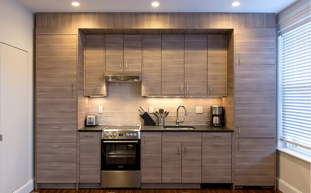 Photo of a contemporary kitchen in Boston with an undermount sink, light wood cabinets, granite benchtops, brown splashback, glass tile splashback and stainless steel appliances.