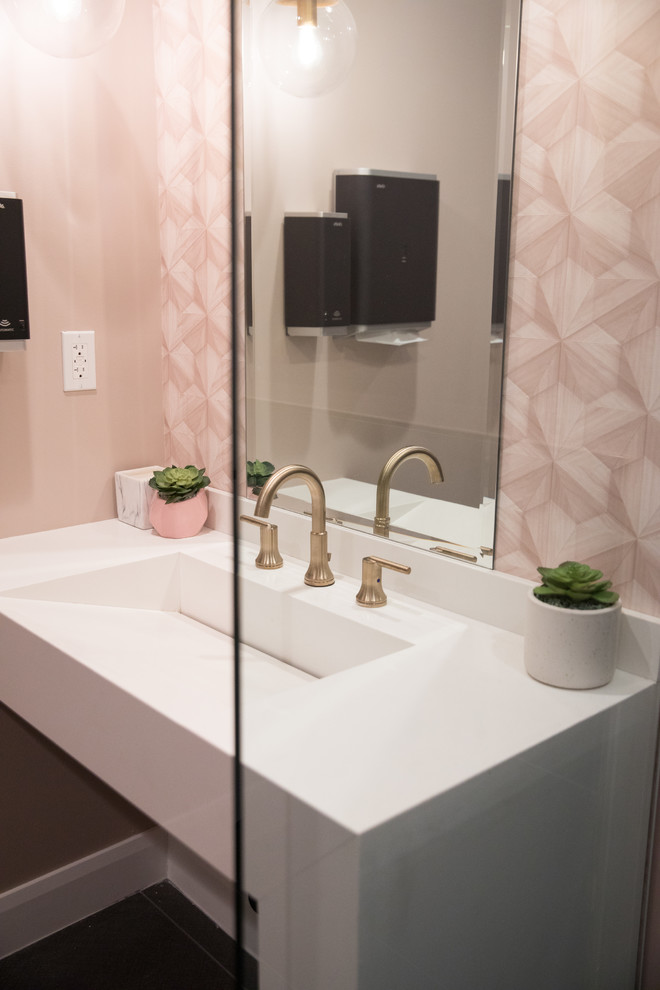 This is an example of a mid-sized contemporary 3/4 bathroom in Los Angeles with a two-piece toilet, gray tile, ceramic tile, pink walls, ceramic floors, an integrated sink and grey floor.