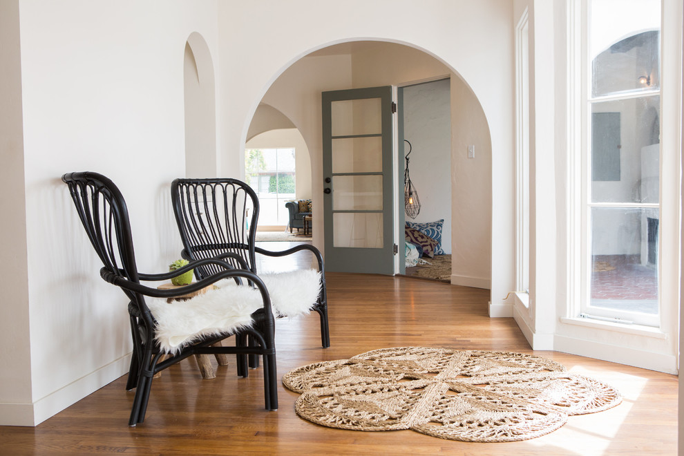 Design ideas for a mid-sized mediterranean hallway in San Diego with white walls and medium hardwood floors.