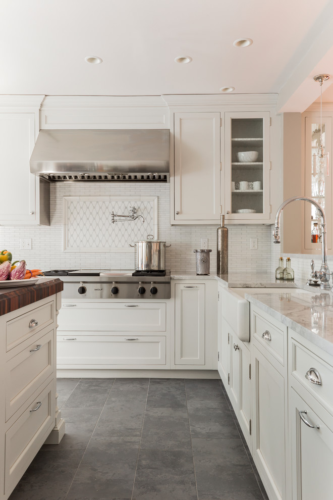 Elegant slate floor and gray floor kitchen photo in Boston with a farmhouse sink, recessed-panel cabinets, white cabinets, white backsplash and stainless steel appliances