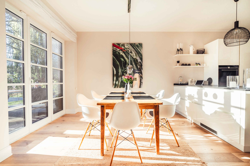 Große Moderne Wohnküche ohne Kamin mit rosa Wandfarbe, hellem Holzboden und braunem Boden in Hamburg