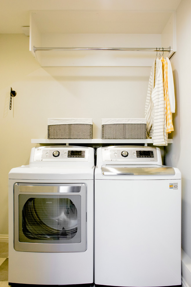 This is an example of a mid-sized transitional single-wall dedicated laundry room in Los Angeles with white cabinets, white walls, porcelain floors and a side-by-side washer and dryer.