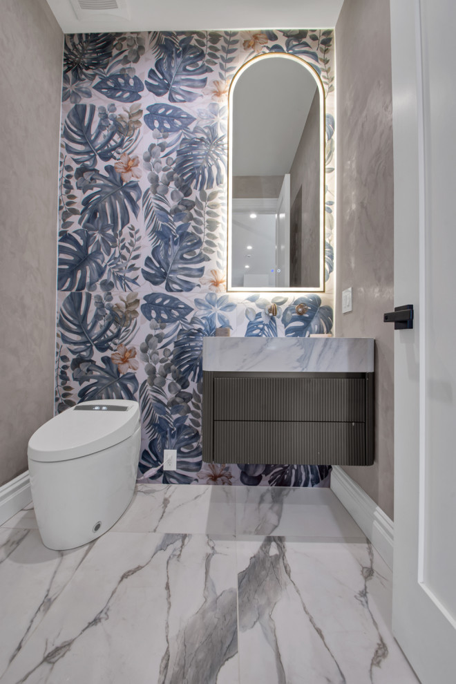 Mittelgroße Rustikale Gästetoilette mit Kassettenfronten, grauen Schränken, Toilette mit Aufsatzspülkasten, blauer Wandfarbe, Granit-Waschbecken/Waschtisch, weißem Boden, schwebendem Waschtisch, Tapetenwänden, farbigen Fliesen, Keramikfliesen, Porzellan-Bodenfliesen, Einbauwaschbecken und bunter Waschtischplatte in New York