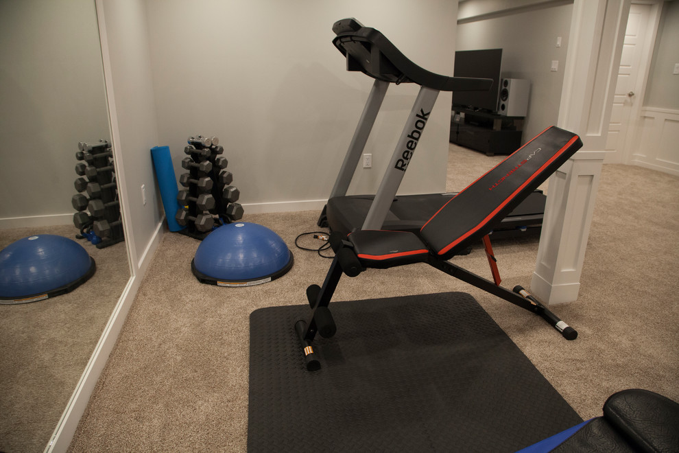 Large country home gym in Edmonton with grey walls, carpet and beige floor.