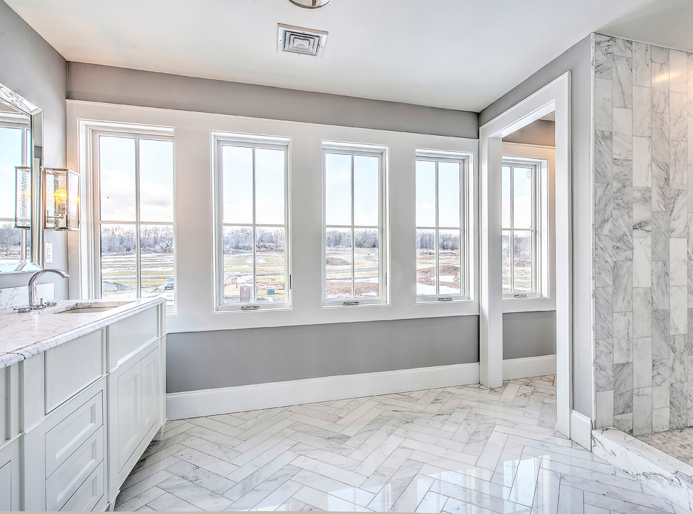 Doorless shower - mid-sized cottage master white tile and stone tile marble floor doorless shower idea in New York with flat-panel cabinets, white cabinets, a one-piece toilet, white walls, an undermount sink and marble countertops