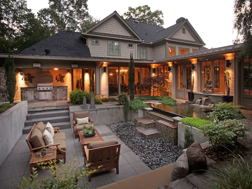 Photo of a large country backyard patio in Atlanta with a water feature, natural stone pavers and a pergola.