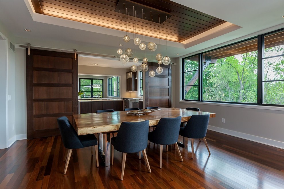 Photo of a mid-sized modern open plan dining in Detroit with grey walls, medium hardwood floors and no fireplace.