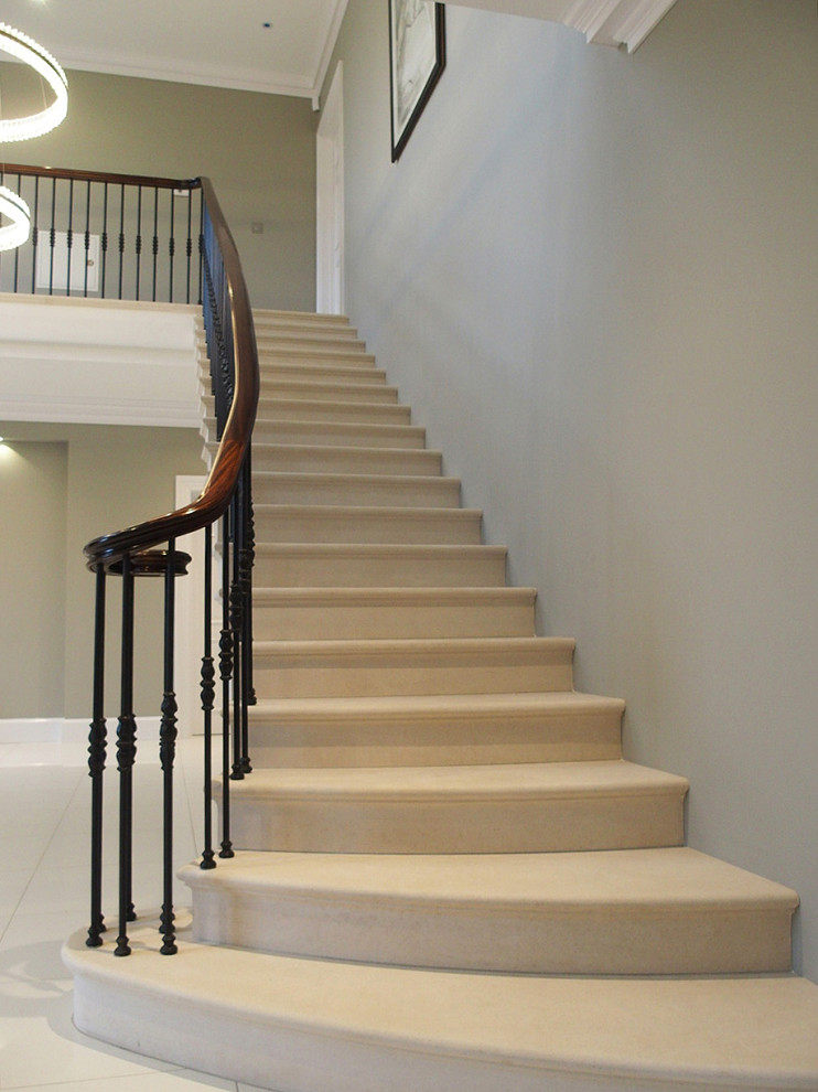 Ejemplo de escalera recta contemporánea con escalones de piedra caliza, contrahuellas de piedra caliza y barandilla de metal