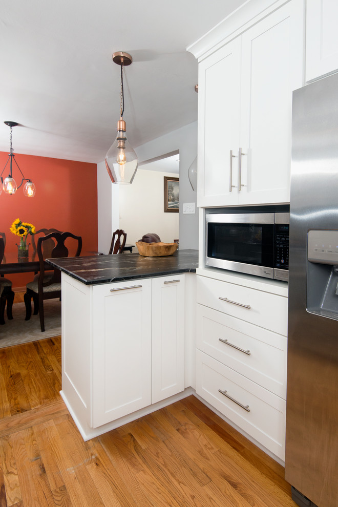 Mid-sized transitional u-shaped medium tone wood floor and beige floor eat-in kitchen photo with a farmhouse sink, shaker cabinets, gray cabinets, marble countertops, multicolored backsplash, stone tile backsplash, stainless steel appliances, a peninsula and black countertops