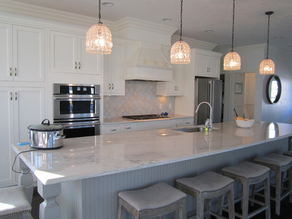 Design ideas for a beach style kitchen in Portland Maine with an undermount sink, shaker cabinets, white cabinets, quartzite benchtops, multi-coloured splashback, stainless steel appliances, with island and white benchtop.