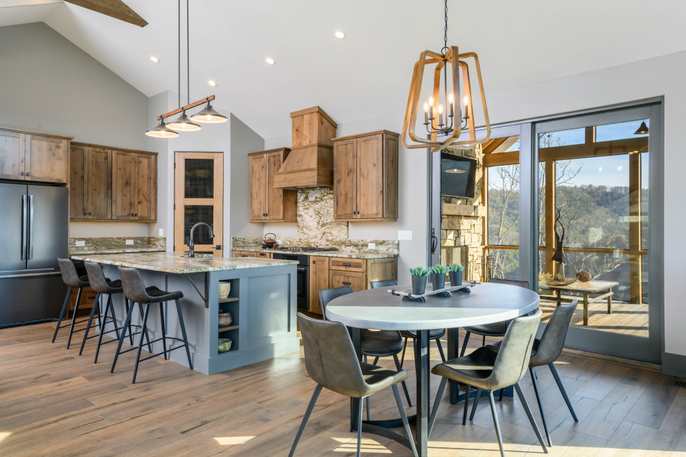 Inspiration for a transitional l-shaped medium tone wood floor and brown floor eat-in kitchen remodel with an undermount sink, shaker cabinets, medium tone wood cabinets, multicolored backsplash, stone slab backsplash, stainless steel appliances, an island and multicolored countertops
