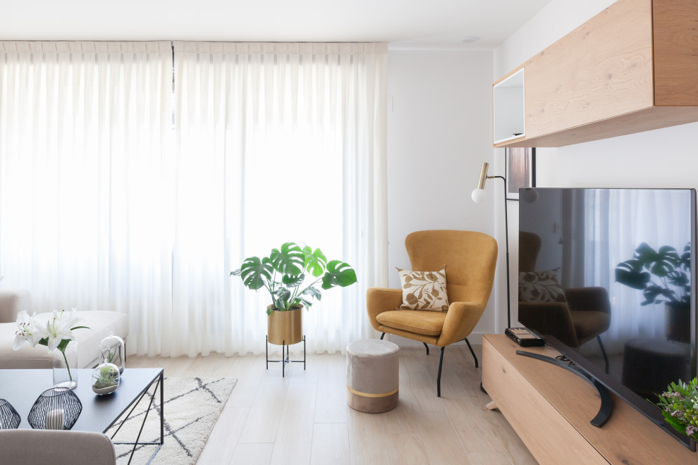 Стильный дизайн: изолированная гостиная комната среднего размера в современном стиле с белыми стенами, светлым паркетным полом, телевизором на стене, коричневым полом и ковром на полу - последний тренд