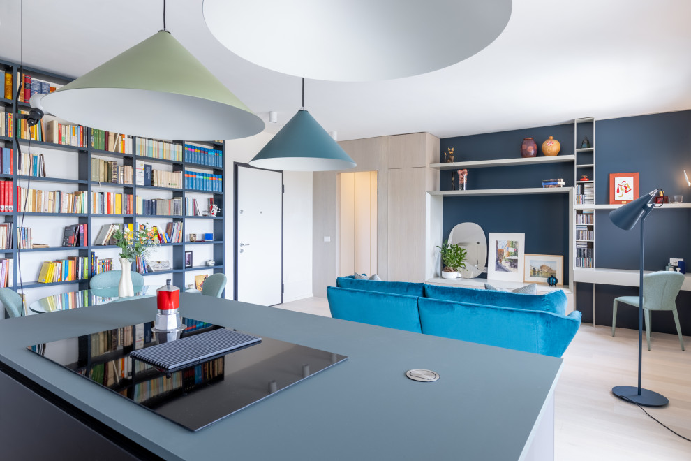 Design ideas for a mid-sized modern galley open plan kitchen in Rome with an undermount sink, glass-front cabinets, turquoise cabinets, solid surface benchtops, black splashback, light hardwood floors, with island, beige floor and black benchtop.