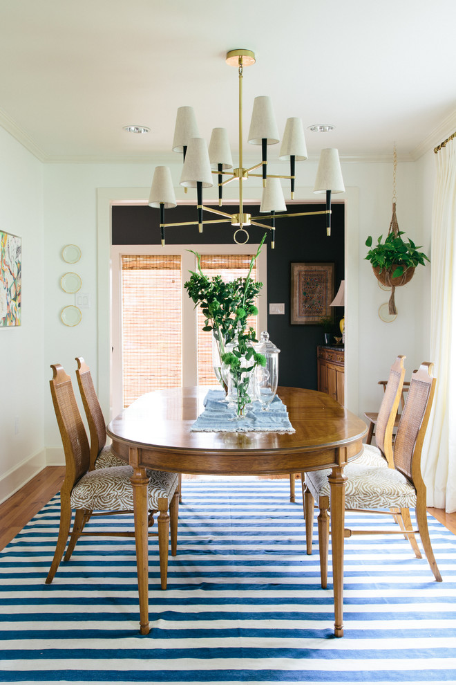Photo of a mid-sized eclectic separate dining room in New Orleans with white walls, medium hardwood floors and no fireplace.
