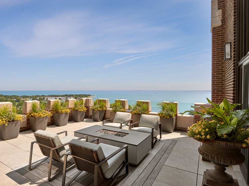 Inspiration for a large transitional rooftop deck remodel in Chicago with a fire pit